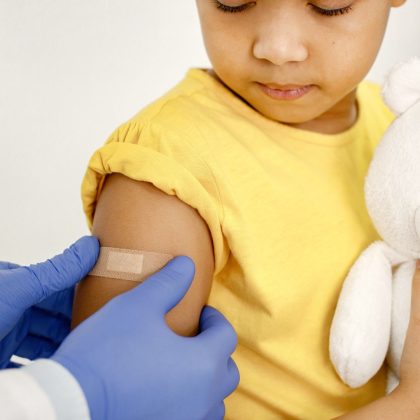 Doctor Putting Band-Aid on the Arm of Girl After Vaccine