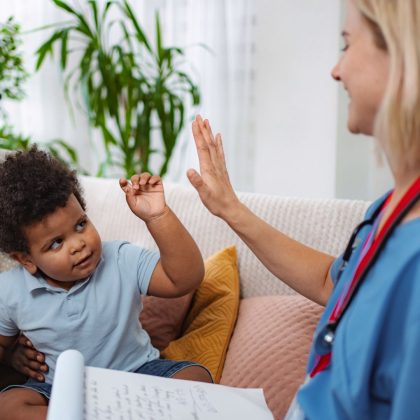 Child health consultation. Doctor and child high fiving