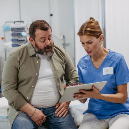 Female doctor consulting with male patient, discussing test result in doctor office